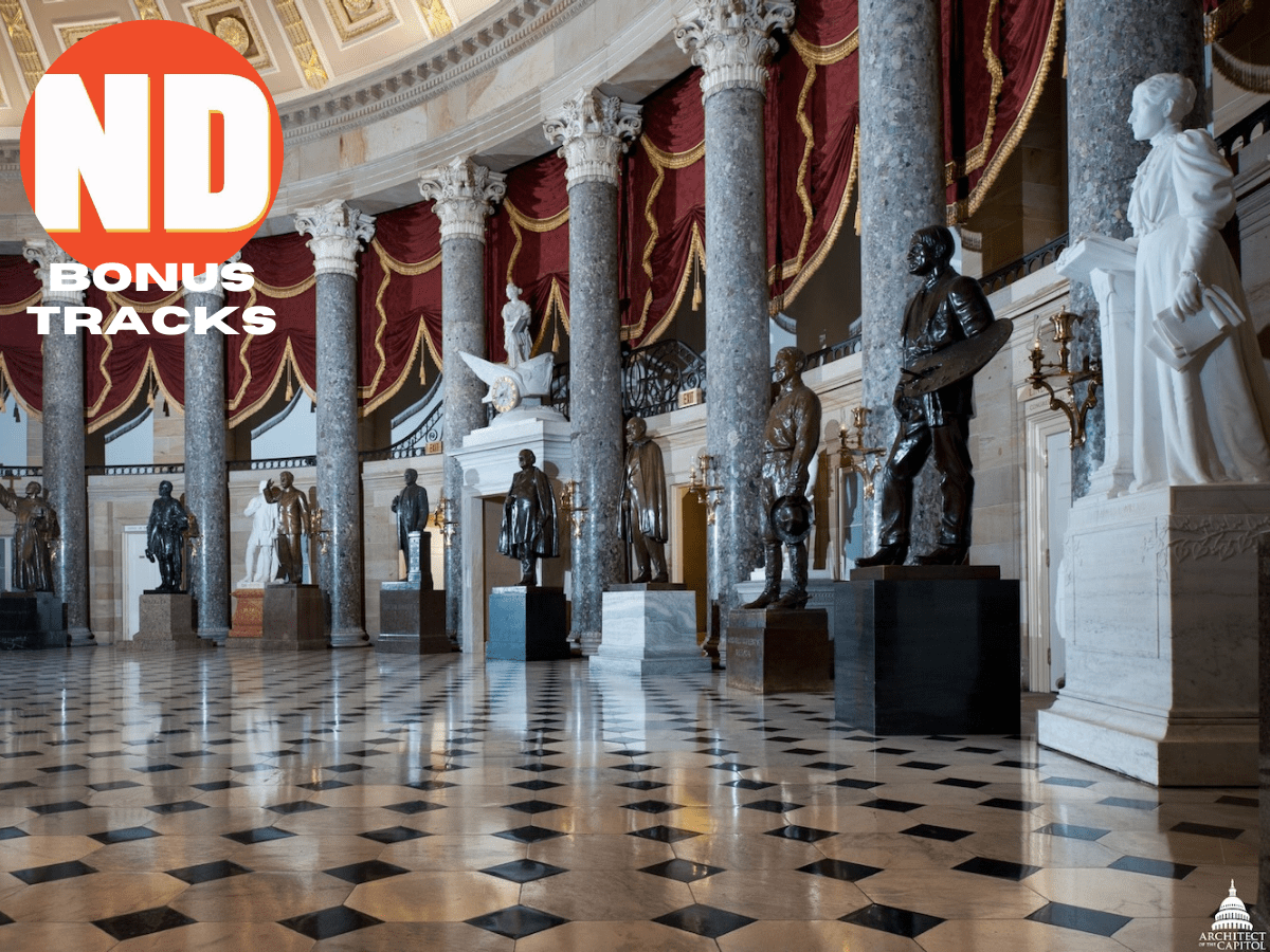 An ornate hall with curved wall lined up bronze and marble statues