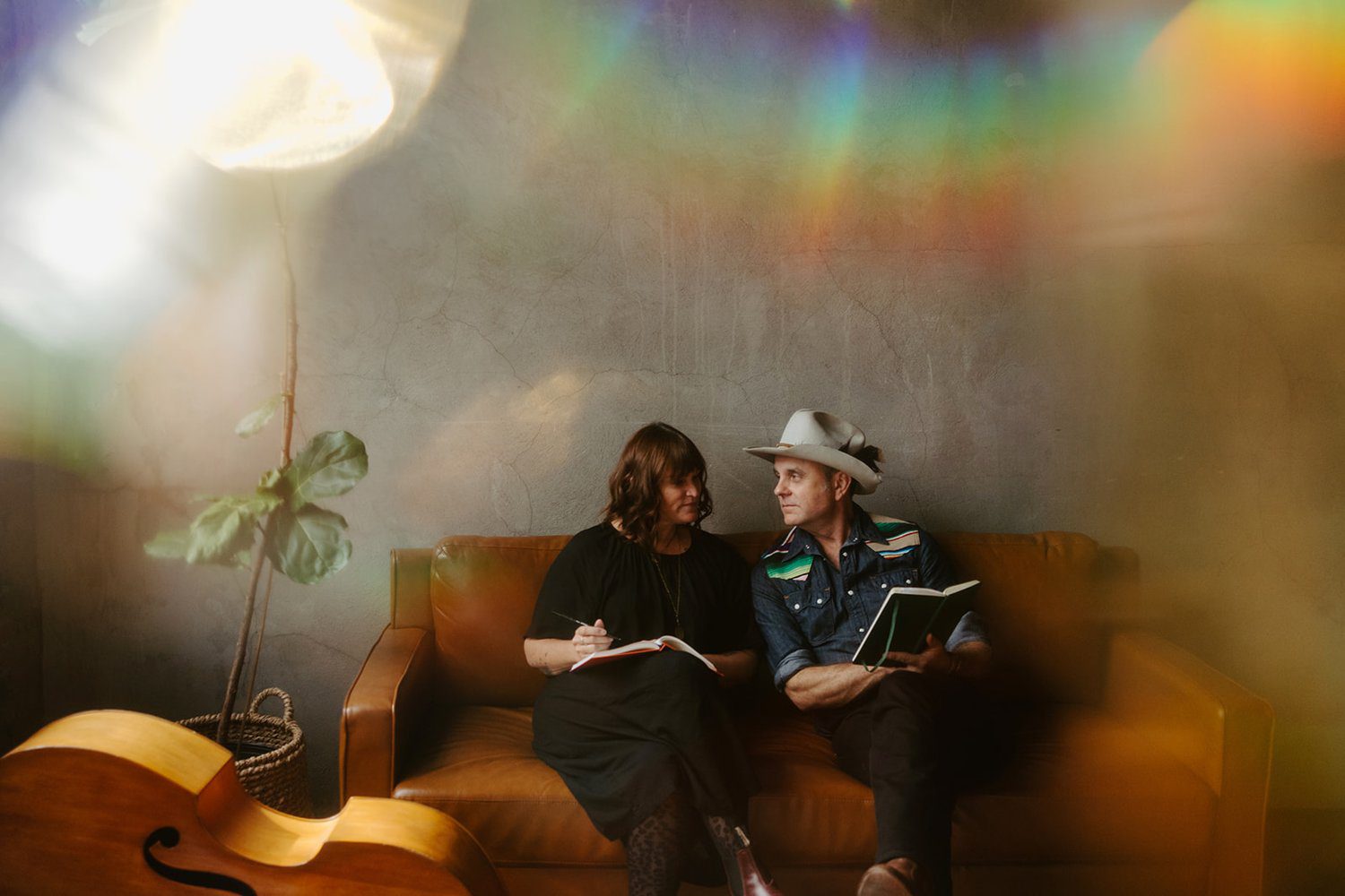 Doug and Telisha Williams seated on a sofa holding books